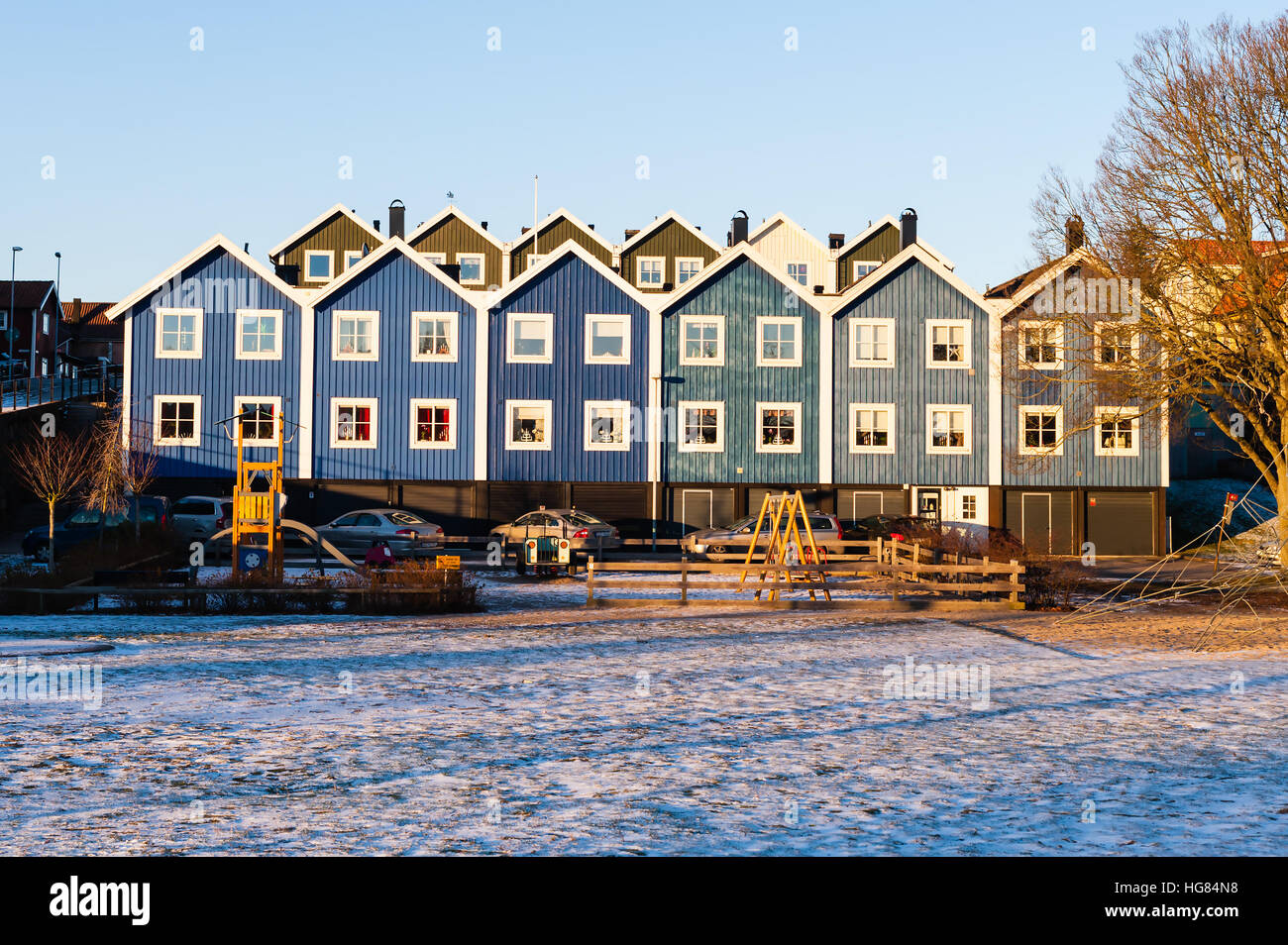 Karlskrona, Svezia - 5 Gennaio 2017: documentario svedese di uno stile di vita urbano. Case affiancate in sfumature di blu. Parco giochi esterno e un po' di neve o Foto Stock
