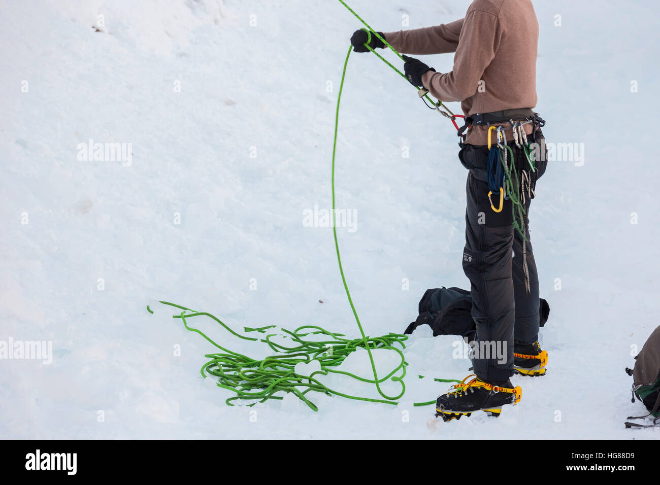 Ouray, Colorado - uno scalatore belays il suo partner mentre l arrampicata su ghiaccio in Ouray Ice Park. Foto Stock