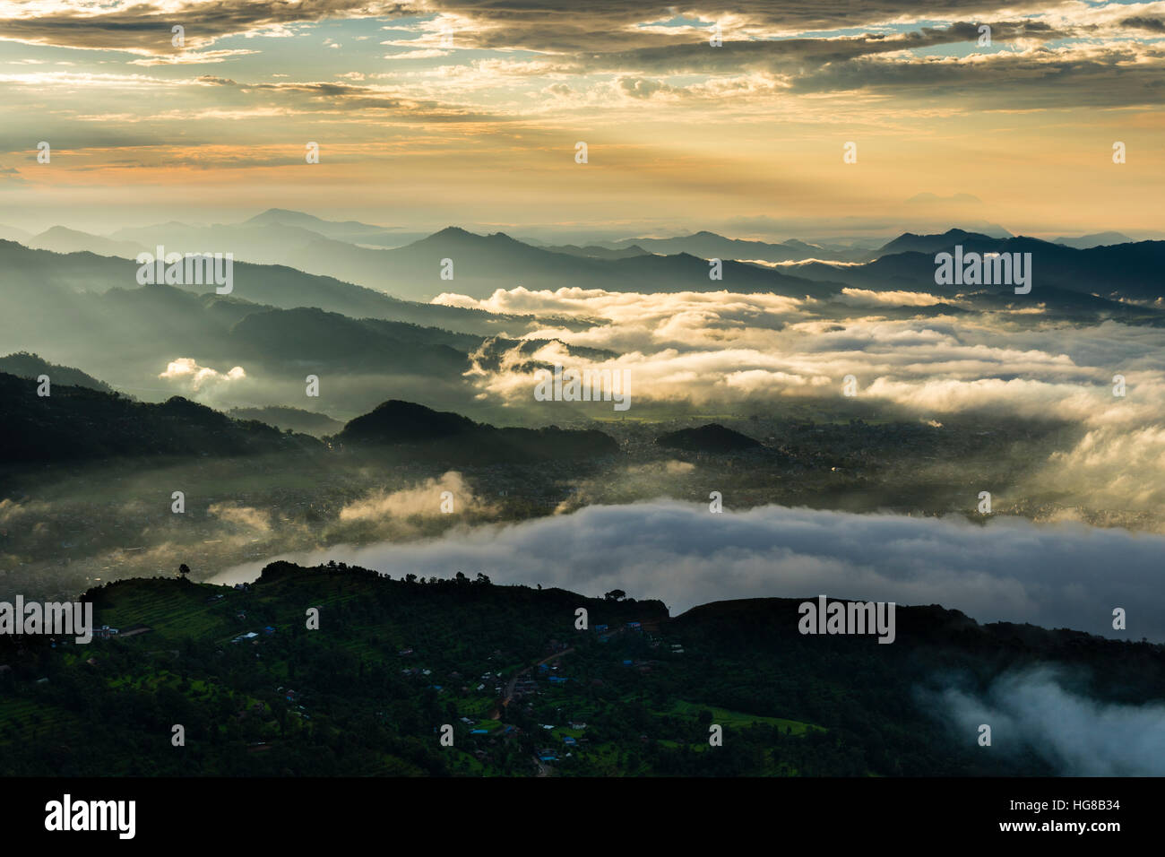 Vista su tutta una gamma di montagna, nelle vallate coperta di nebbia, all'alba, Pame, Kaski District, Nepal Foto Stock