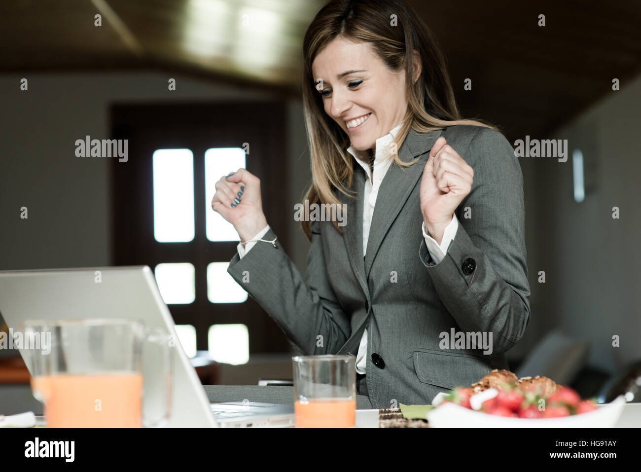 Imprenditrice eccitato a lavorare al PC durante la prima colazione Foto Stock