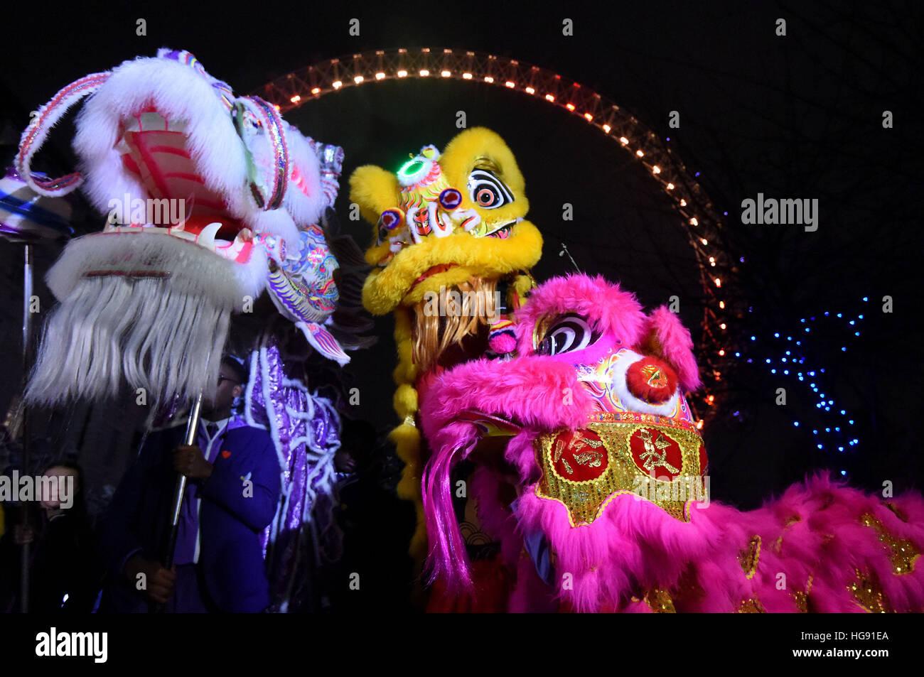 La gente ballare in dragone cinese costumi durante il lancio di Londra 2017 Cinese Capodanno presso il London Eye. Foto Stock