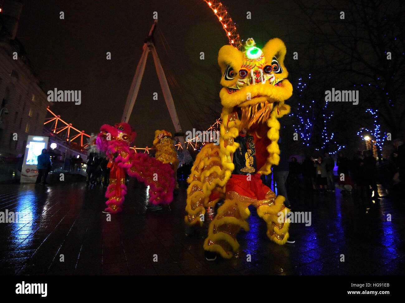 La gente ballare in dragone cinese costumi durante il lancio di Londra 2017 Cinese Capodanno presso il London Eye. Foto Stock