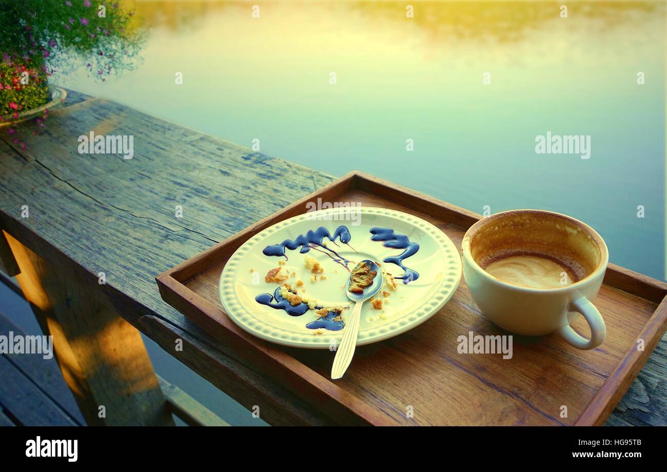 Svuotare tazza di caffè e piastra bianca con pasticcini di mangiato torta e utilizzato cucchiaio , sporca dopo aver finito la prima colazione. Foto Stock