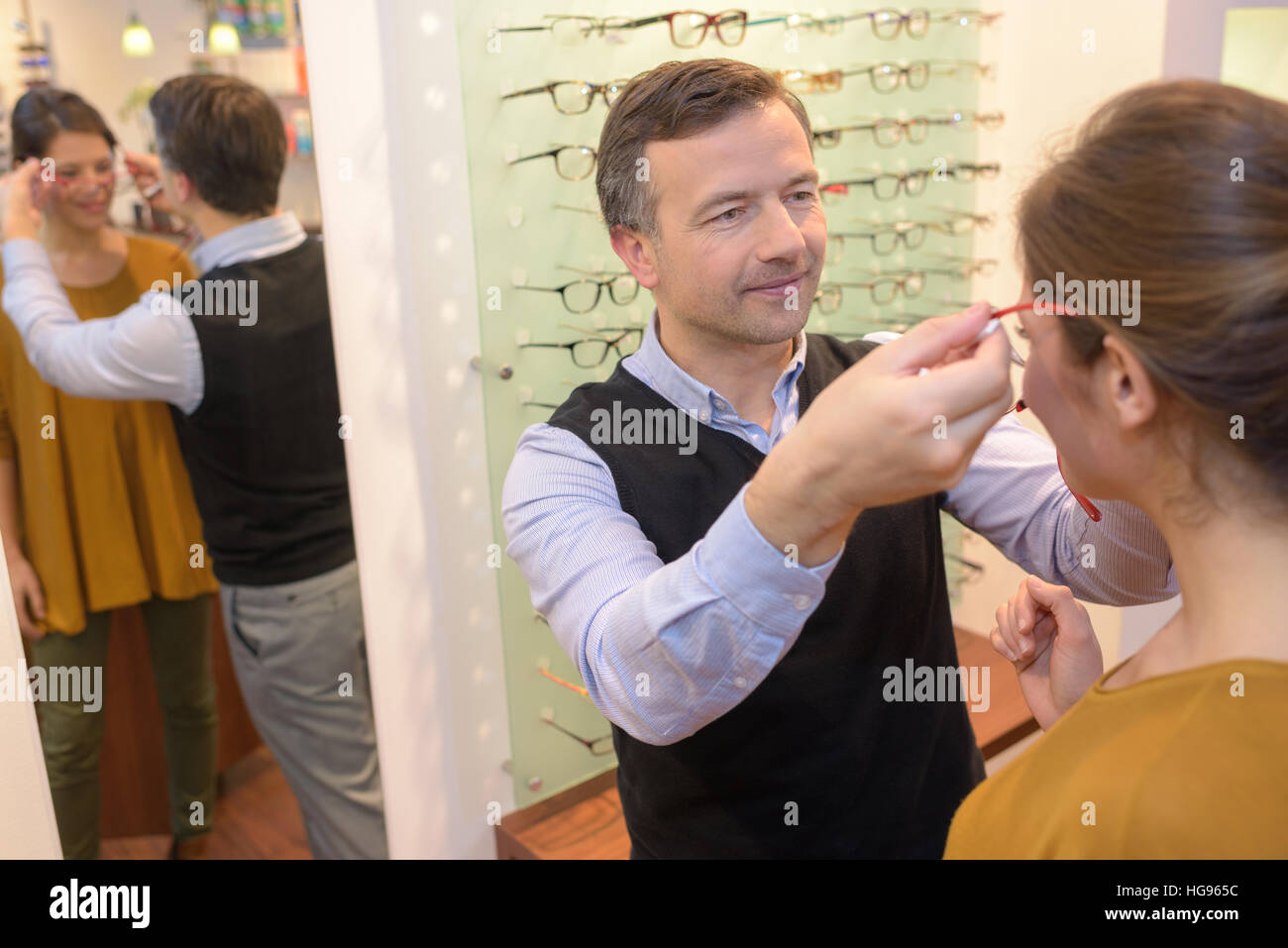 Oculista e bella bruna donne che scelgono gli occhiali in ottica store Foto Stock