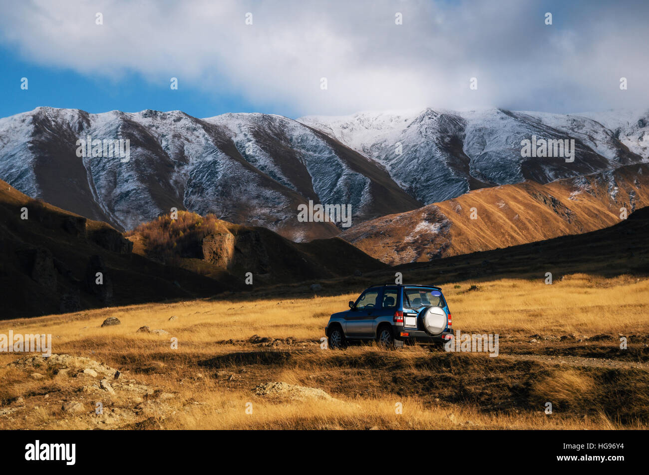 Off-road viaggio su auto sulla strada di montagna contro le rocce e ghiacciai in Caucaso, la Georgia. Belle luci e colori al tramonto Foto Stock