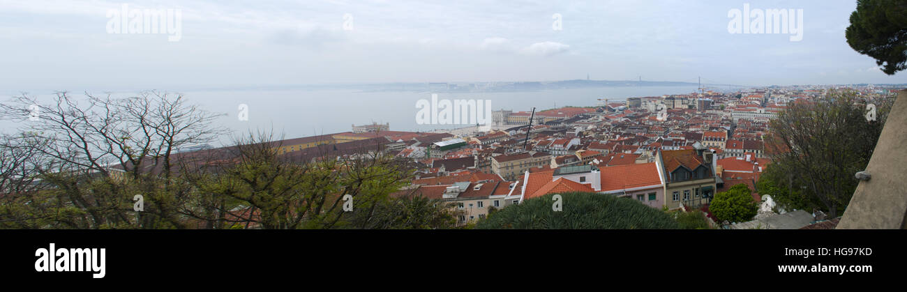 Il Portogallo, Europa: lo skyline di Lisbona con vista dei tetti rossi e i palazzi della Città Vecchia con il XXV Aprile del ponte e il fiume Tago Foto Stock