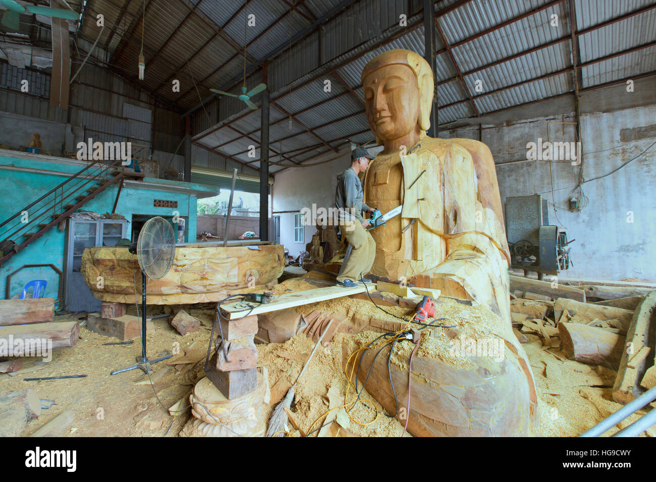 Carver completando Buddha gigante carving. Foto Stock