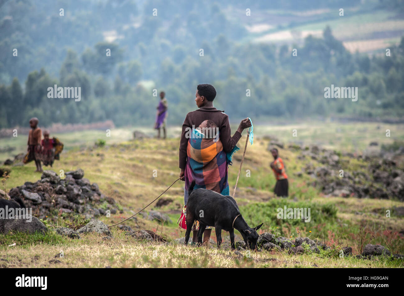 Un pigmeo Batwa che era stato cacciato fuori della sua foresta nativa sorge su una montagna Muhabura nel distretto di Kisoro, Uganda. Foto Stock