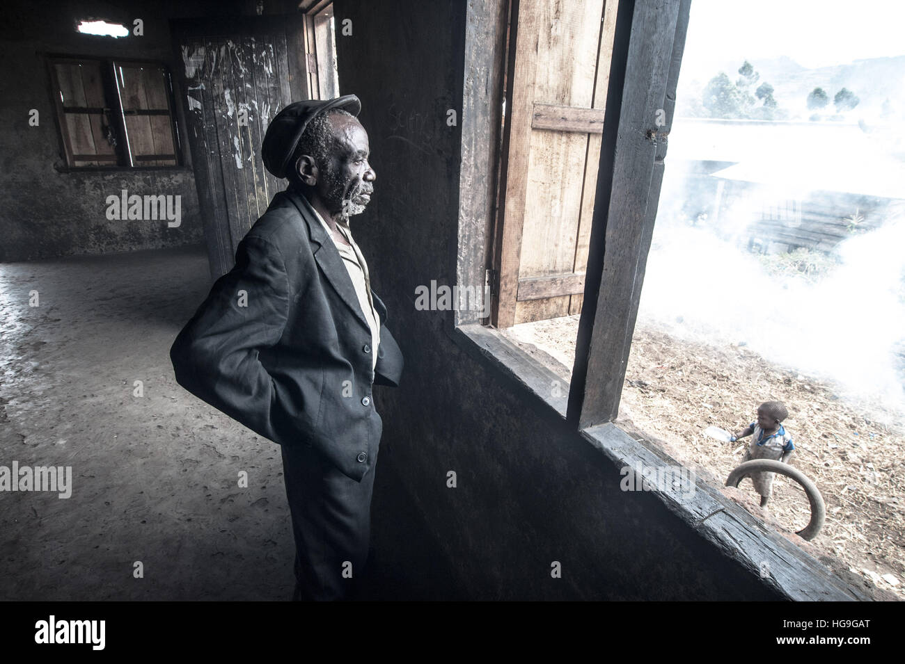 Un pigmeo Batwa che era stato cacciato fuori della sua foresta nativa sorge in una casa nella città di Kisoro, Uganda Foto Stock