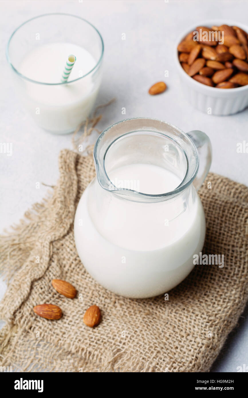 Brocca del latte di mandorla sul panno di lino. Sana, vegan dairy-free latte. Foto Stock