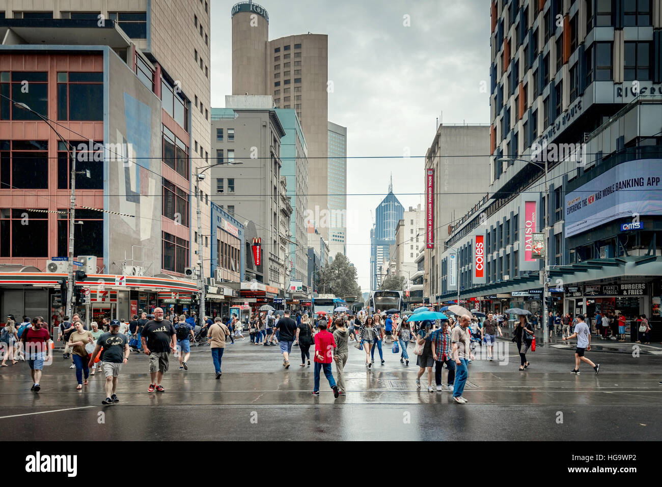 Melbourne, Australia - 27 dicembre 2016: le persone che attraversano l'intersezione di Elizabeth e la Flinders Street, nella città di Melbourne quartiere degli affari Foto Stock