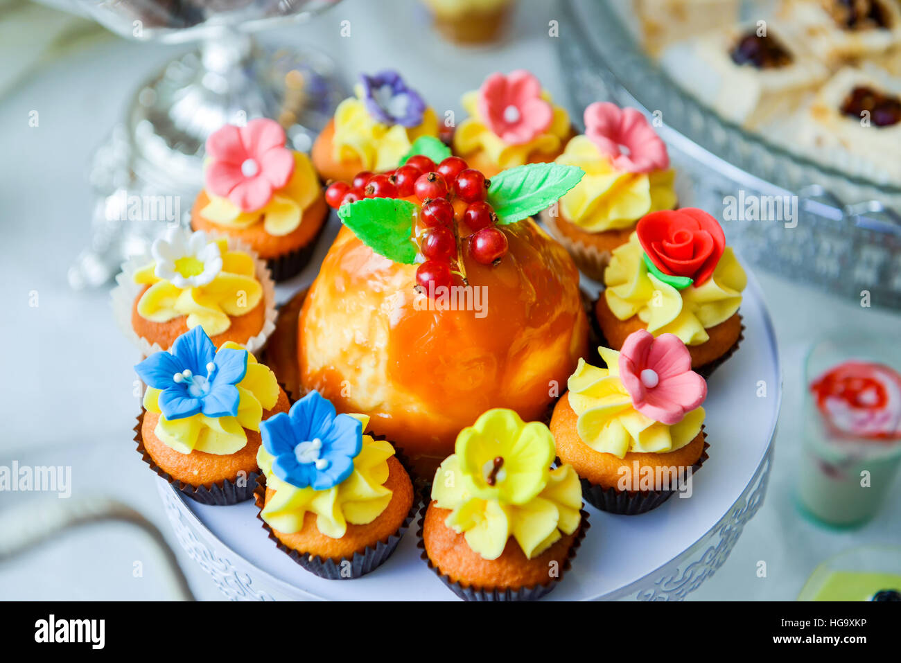 Muffin decorati con crema di fiori sul tavolo Foto Stock