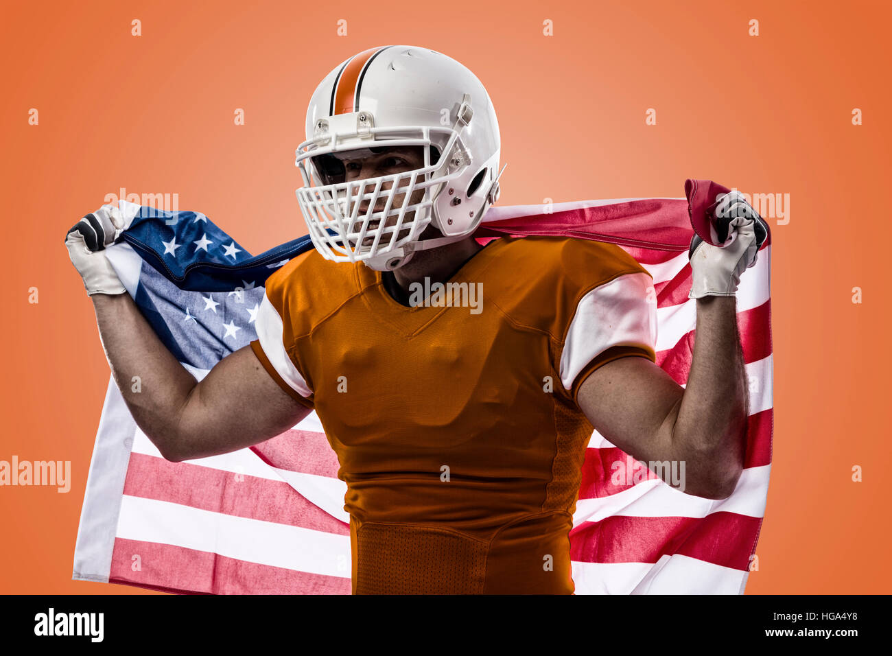 Giocatore di calcio con un arancio uniforme e una bandiera americana, su uno sfondo arancione. Foto Stock