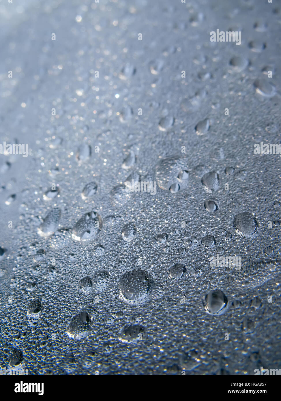 Texture di sfondo di gocce di acqua e gocce su una superficie di vetro con vista prospettica Foto Stock