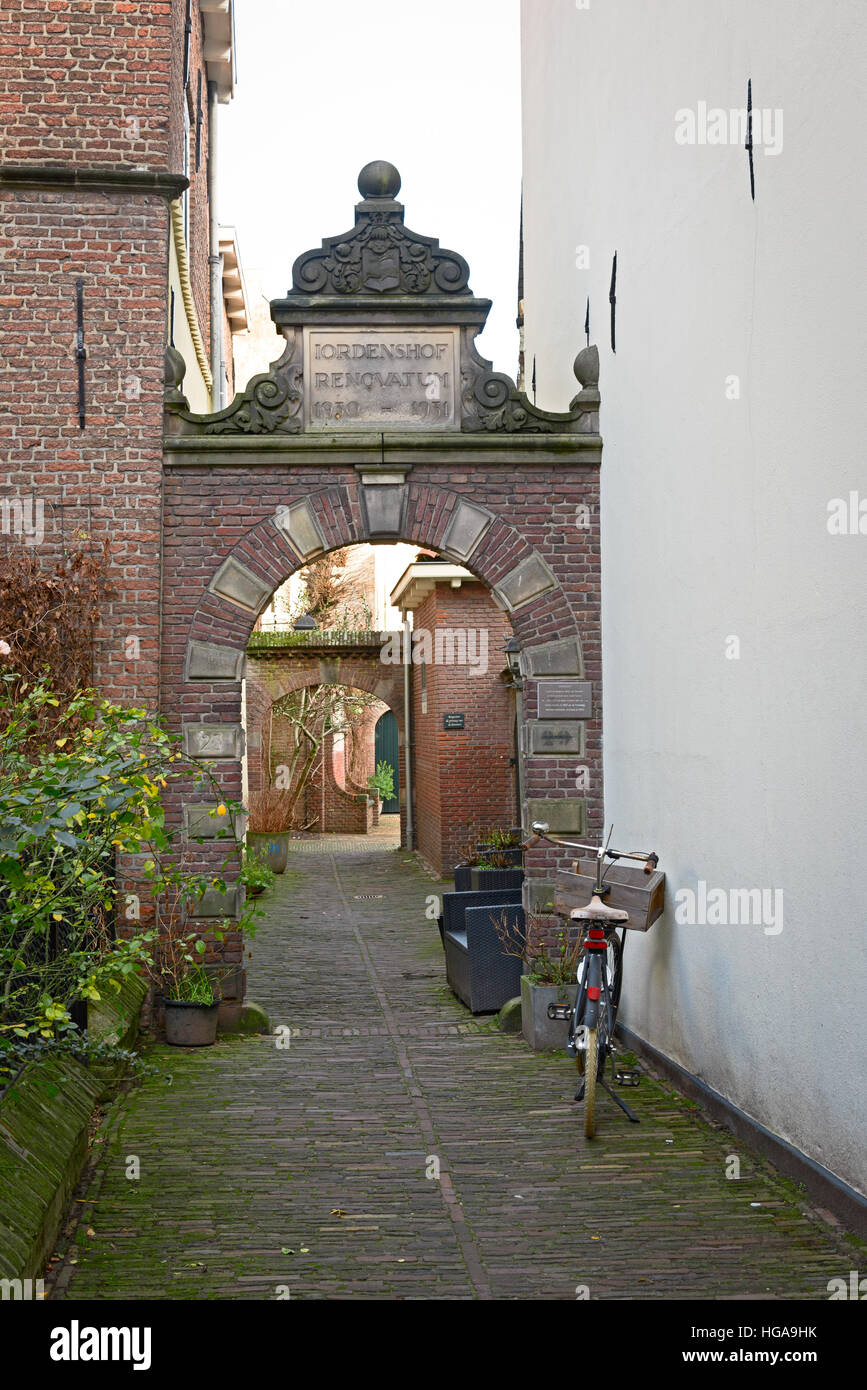 Bicicletta parcheggiata in strada stretta a Deventer, una tipica scena olandese Foto Stock