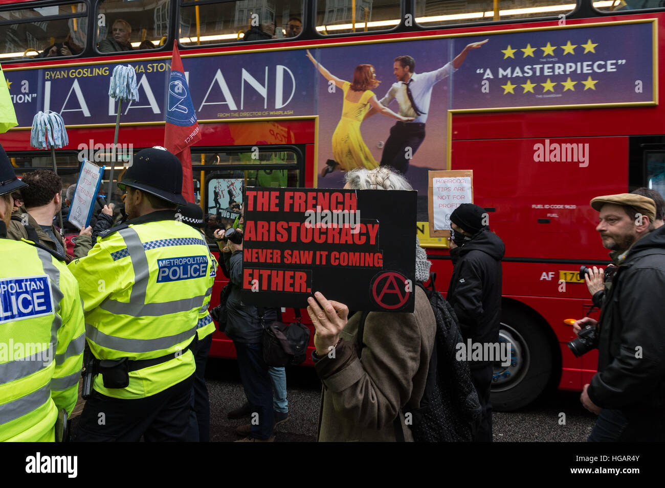 Londra, Regno Unito. Il 7 gennaio 2017. Voci unite dell unione mondiale organizzata la protesta fuori Luxury department store Harrods sulla società di suggerimenti politica nel loro reparto culinario. Circa il 25% dei 12,5% di tassa di servizio aggiunto a ristoranti bollette degli utenti sono condivisi tra il personale di catering mentre i magazzini Harrods, di proprietà del Qatar la famiglia reale, mantiene il resto. I contestatori supportato da militanti anarchici dalla guerra di classe chiamata per puntali trasparenti politica e ha sostenuto che il 100% della carica di servizio dovrebbe andare per i lavoratori. Wiktor Szymanowicz/Alamy Live News Foto Stock