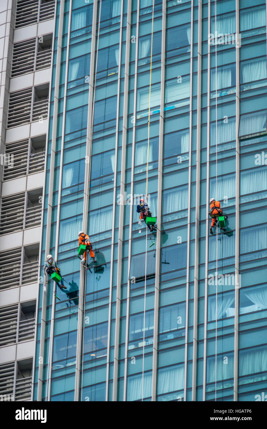 Singapore, nobile finestra di lavoro di pulizia presso l'imponente facciata di vetro di 70 piani @ vele Marina Bay torre condominio Foto Stock