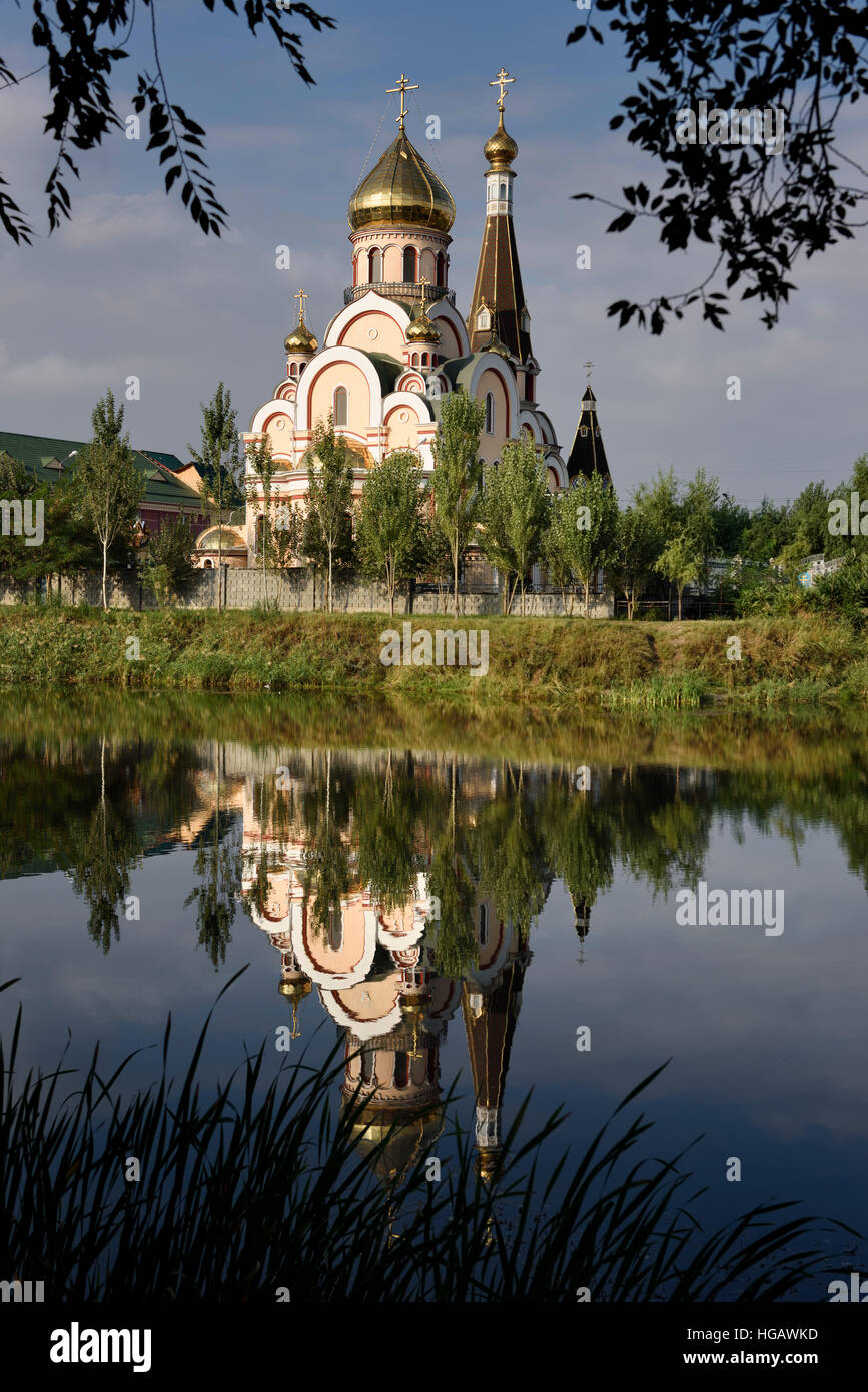 Chiesa ortodossa di esaltazione della Santa Croce in Almaty Kazakhstan riflessa in acqua di stagno Foto Stock