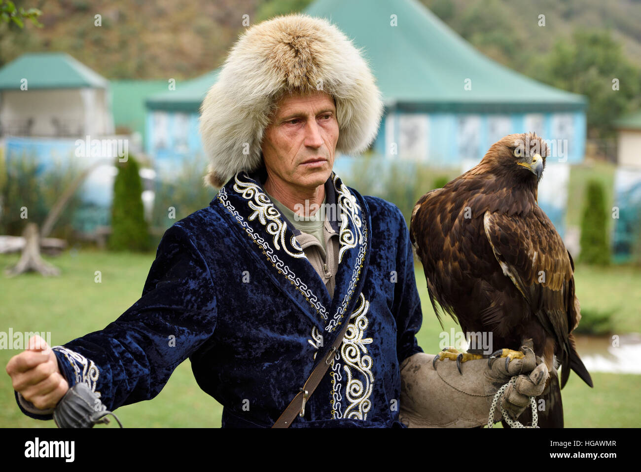 Professional trainer con Golden Eagle a Sunkar Raptor Centre di Alma Arasan Gorge Almaty Kazakhstan Foto Stock