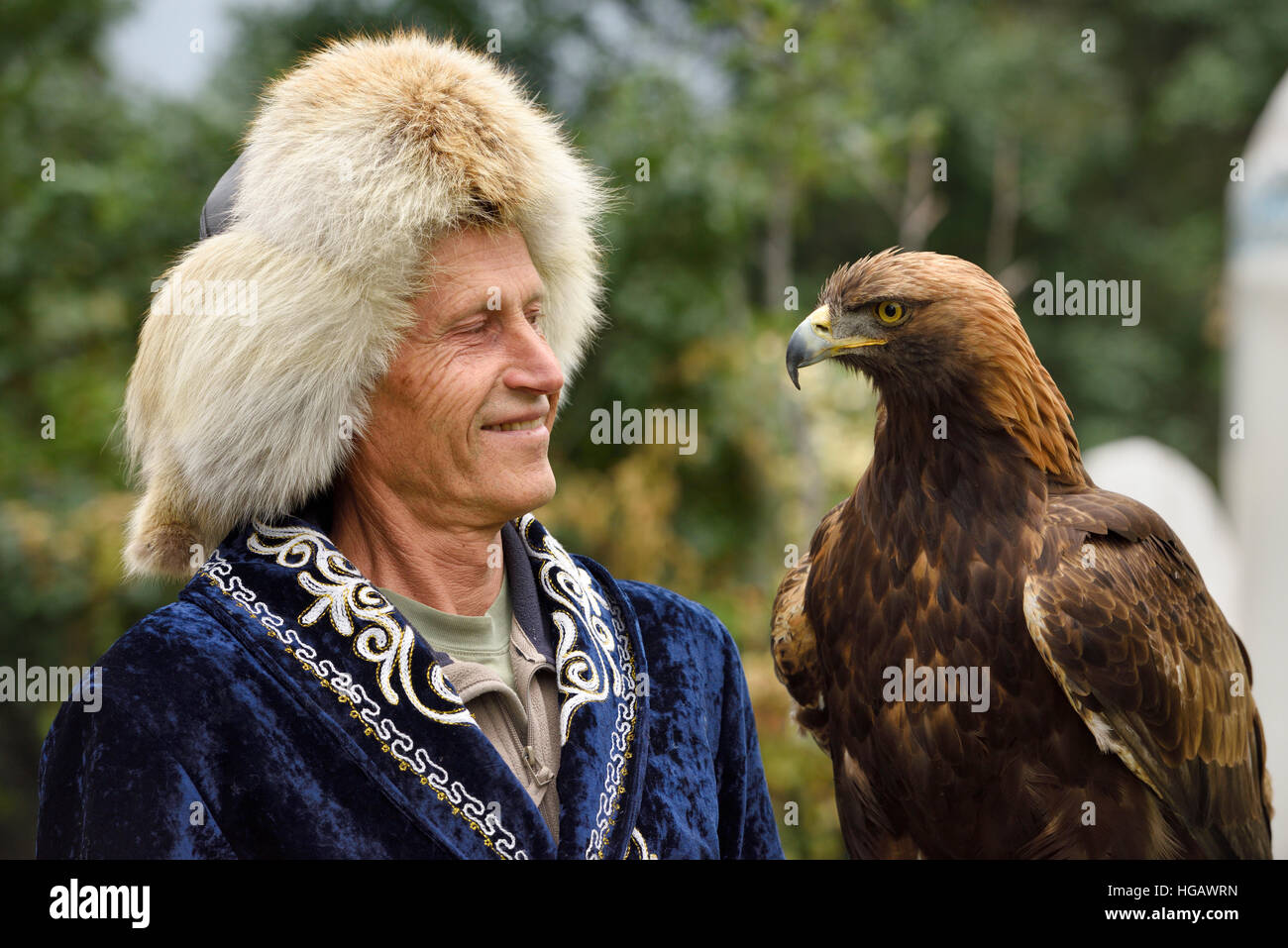 Professional trainer sorridente al Golden Eagle a Sunkar Raptor Centre di Alma Arasan Gorge Almaty Kazakhstan Foto Stock