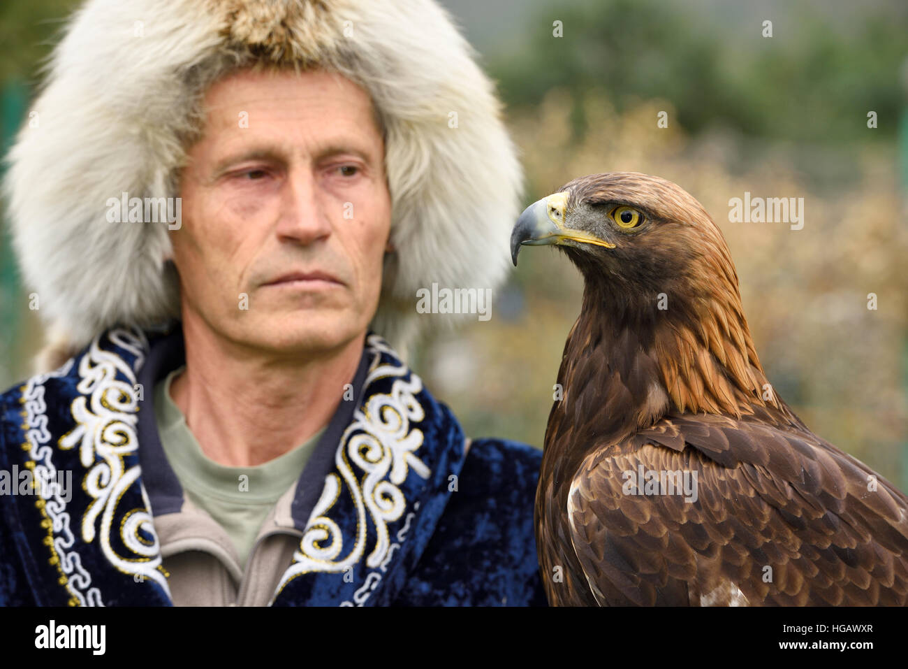 Close up Golden Eagle faccia con bird trainer presso Sunkar Raptor Centre Almaty Kazakhstan Foto Stock