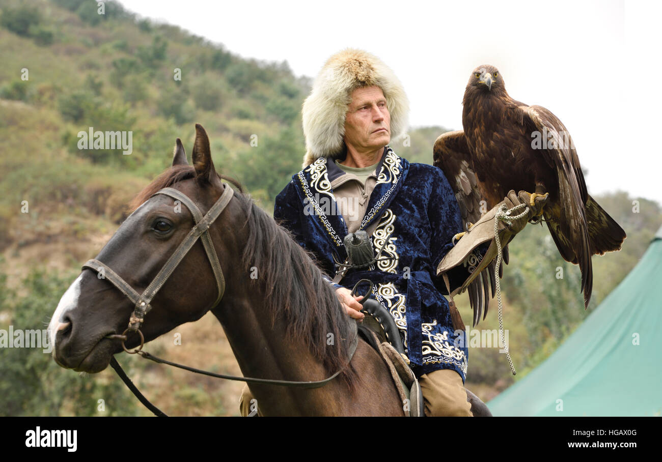 Bird trainer a cavallo e Golden Eagle a Sunkar Raptor Centre Almaty Kazakhstan Foto Stock