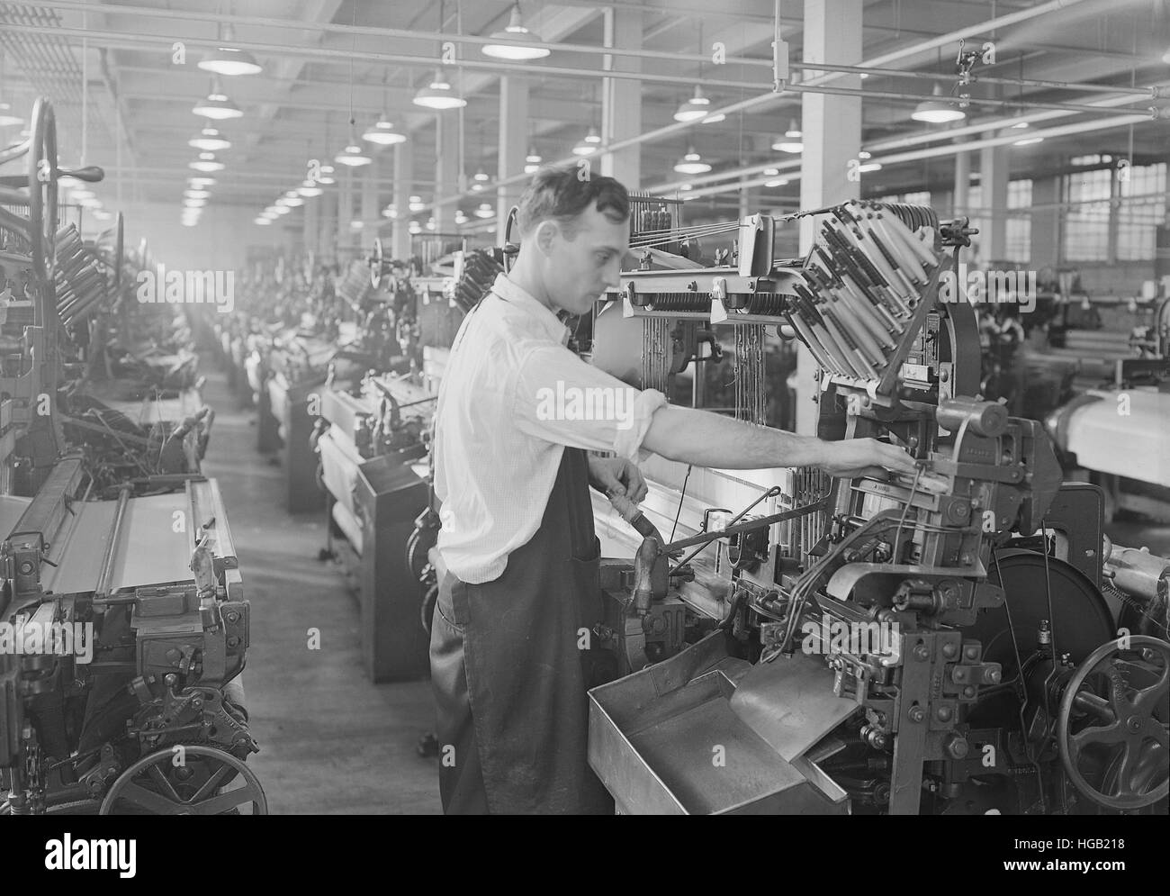 Uomo al lavoro un automatic loom, 1936. Foto Stock