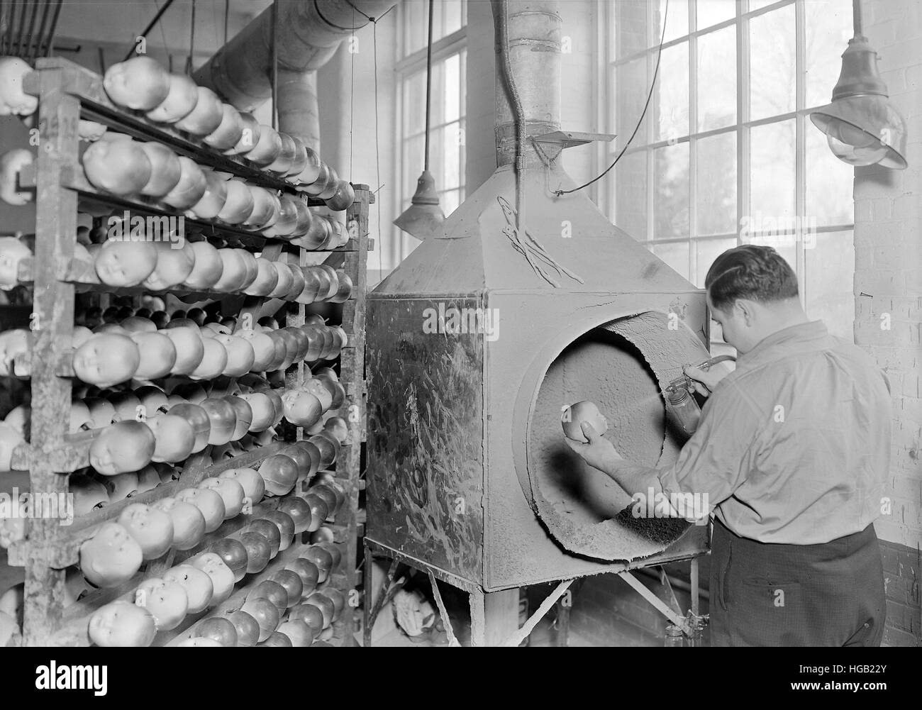 Lavoratore faccia di spruzzatura, le mani e le braccia su Rubber Doll capi, 1936. Foto Stock