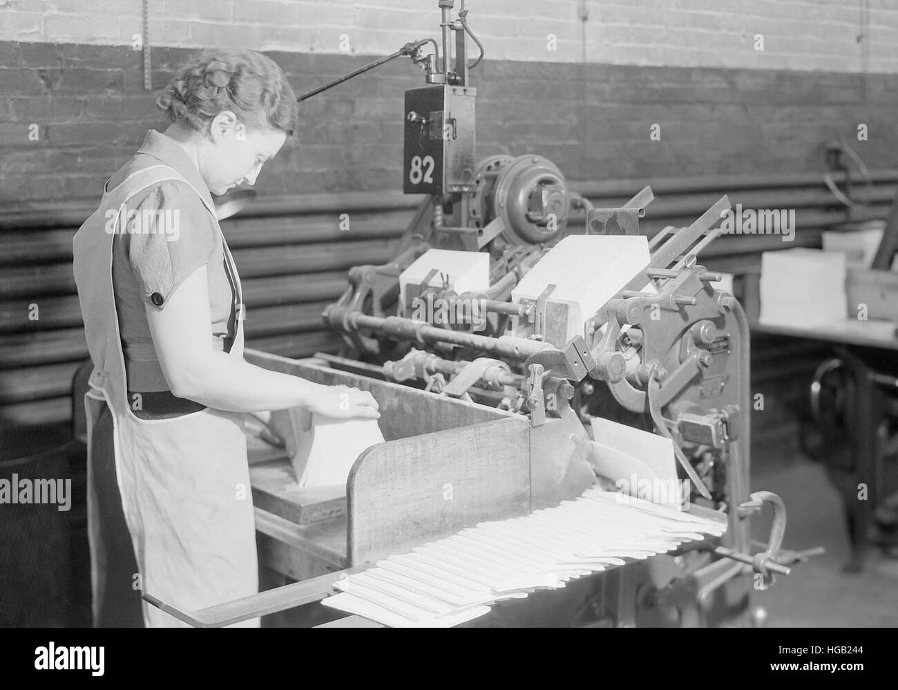 Un esperto donna il funzionamento della macchina ribaltatrice a premere Kingsport, Tennessee, 1933. Foto Stock
