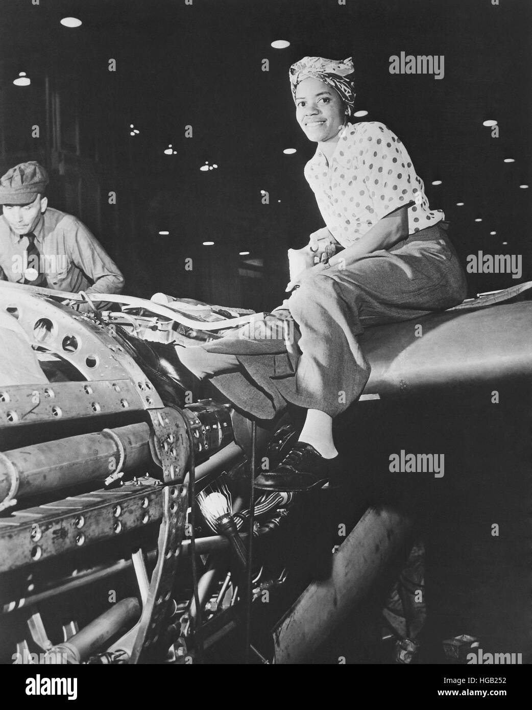 Una rivettatrice femmina lavorando sulla realizzazione di un aereo. Foto Stock