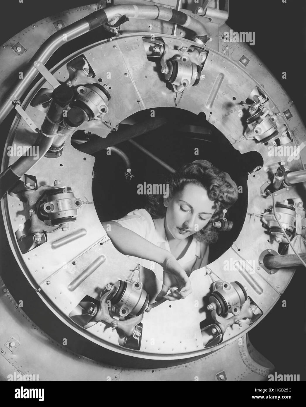 Una donna che monta una parte del cofano di un B-25 bombardiere motore. circa 1942 Foto Stock