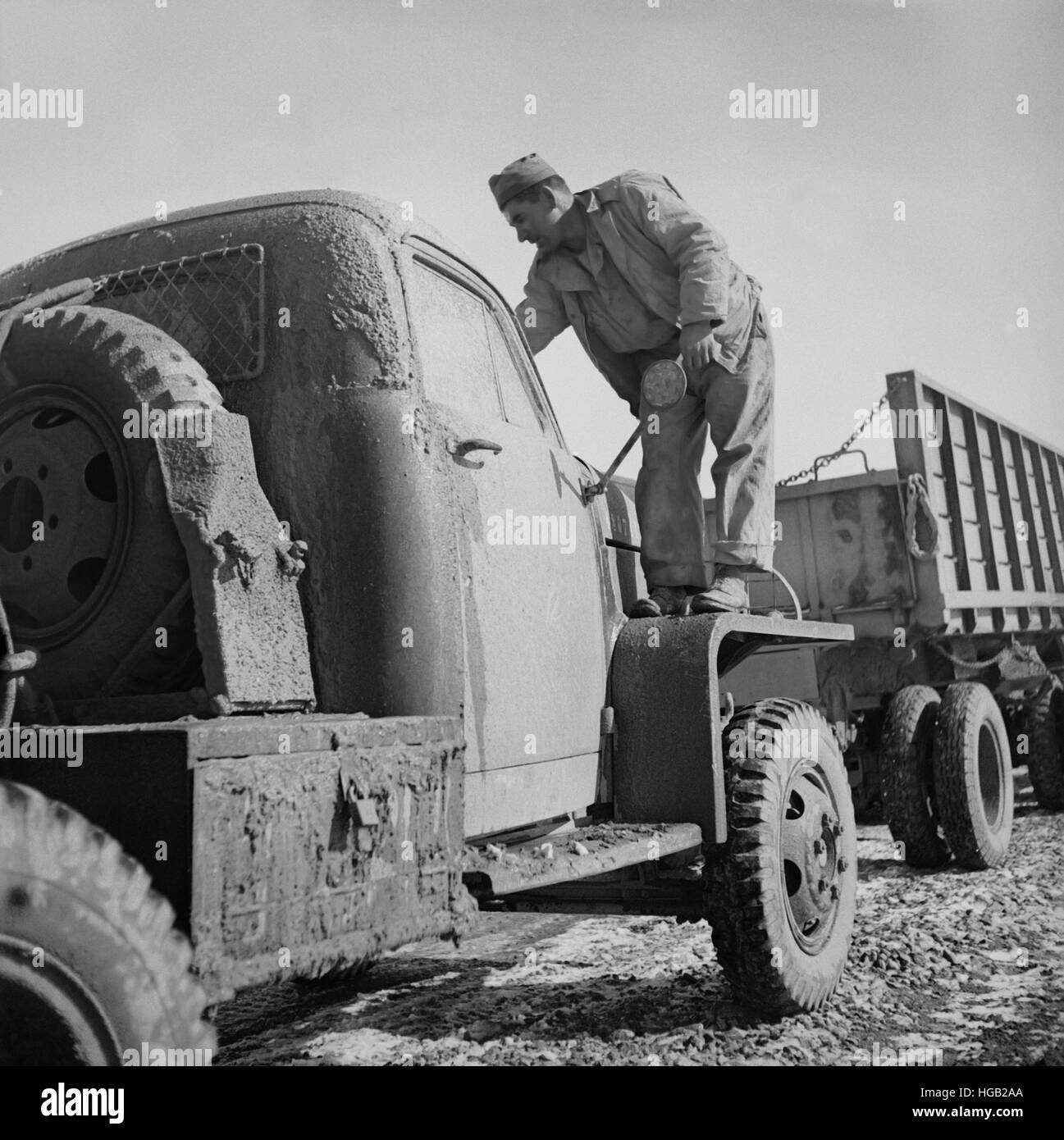 Il conducente è fango di pulizia dal parabrezza del suo carrello, 1943. Foto Stock