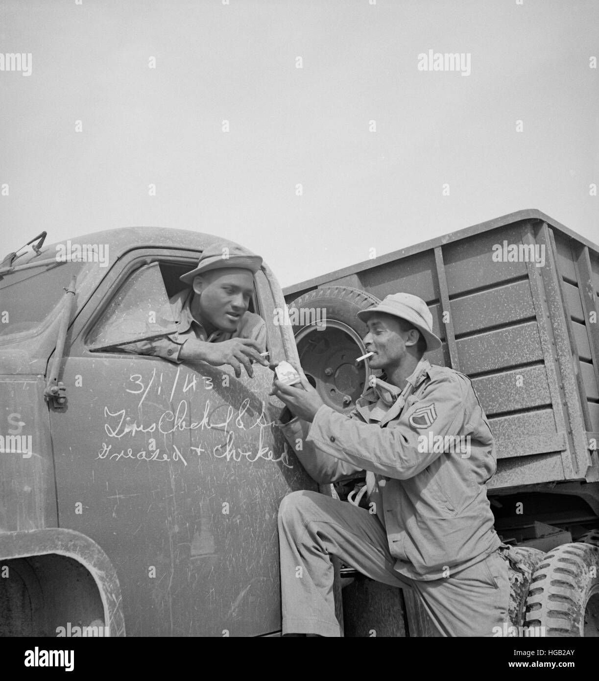 Driver di U.S. Army truck convoglio si arresta per avere un fumo sul deserto, 1943. Foto Stock