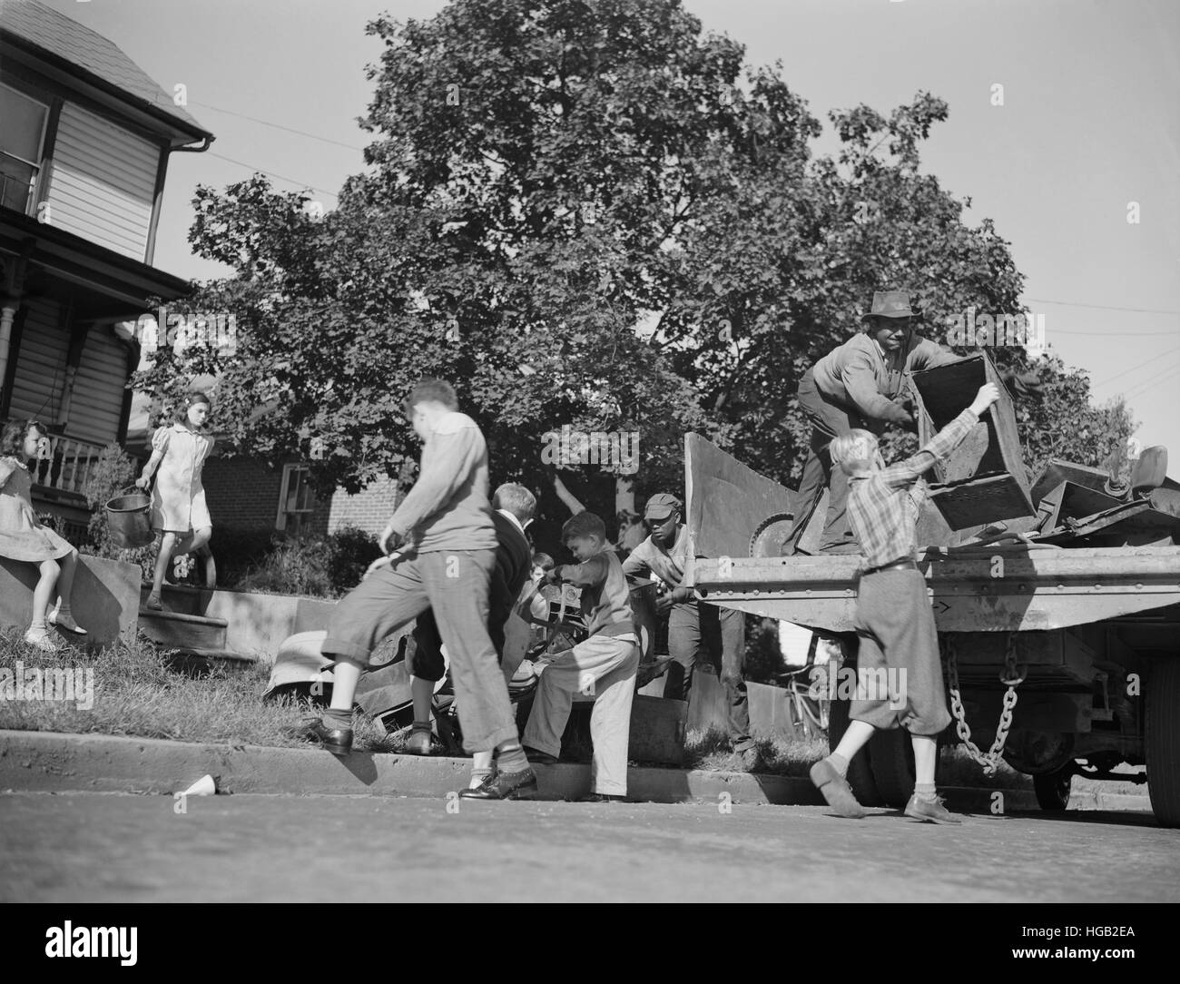 Ragazzi consentono di caricare un carrello con rottami di metallo di donazioni per le loro industrie belliche, 1942. Foto Stock
