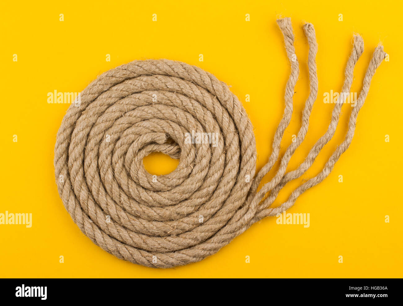 Vista superiore della corda con dipanato fine su sfondo giallo Foto Stock