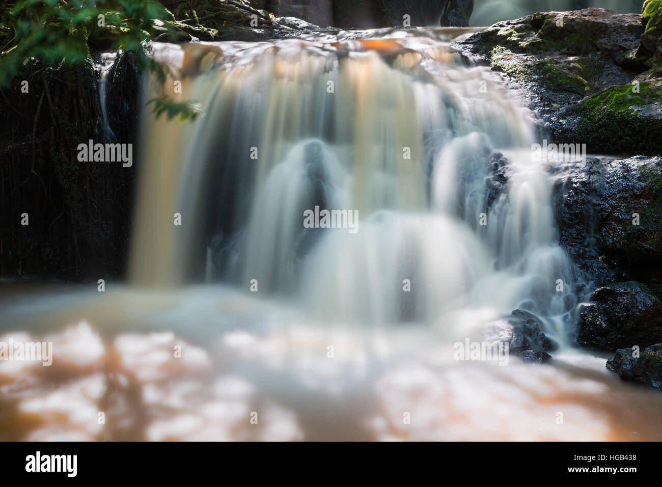 Una lunga esposizione dettaglio colpo di un piccolo fiume di Nairobi cascata nella foresta di Karura, Kenya. Foto Stock