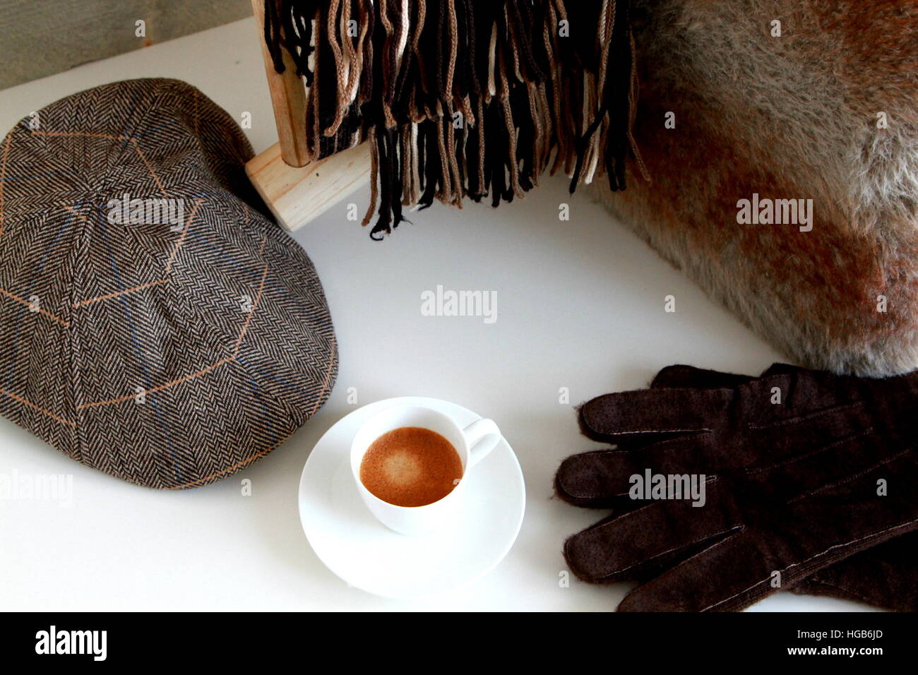 Caffè Espresso con cappello, guanti e sciarpa sul tavolo bianco Foto Stock