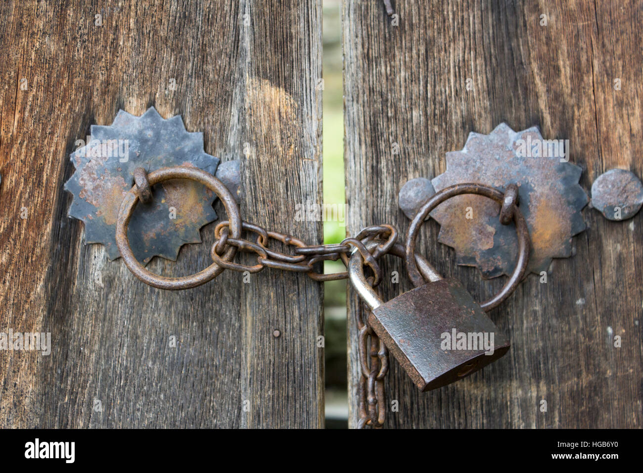 Vecchi cancelli in legno bloccato sul ferro il lucchetto con catena in Villaggio bulgaro Foto Stock
