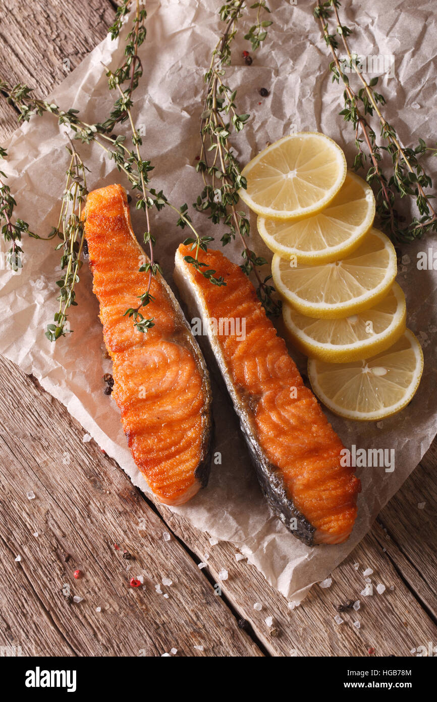 Country Food: salmone alla griglia con limone sul tavolo di close-up. Vista verticale da sopra Foto Stock