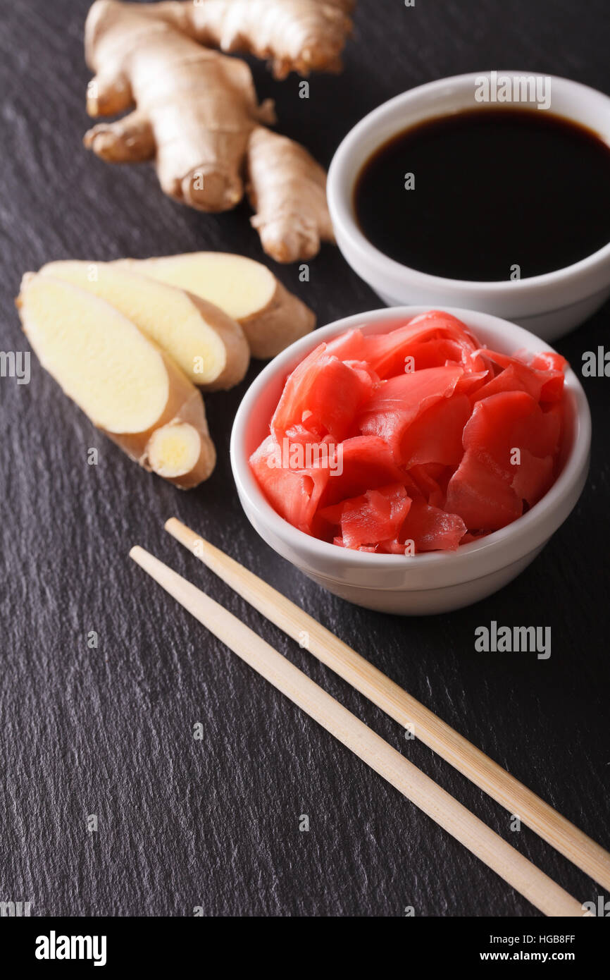 Il condimento per sushi: salsa di soia e zenzero sott'aceto close-up su una scheda di ardesia verticale. Foto Stock