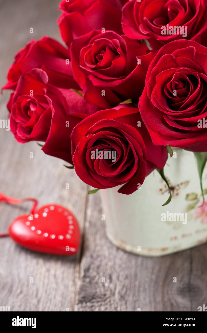 Festive bouquet di rose rosse e di cuore su un vecchio sfondo di legno Foto Stock