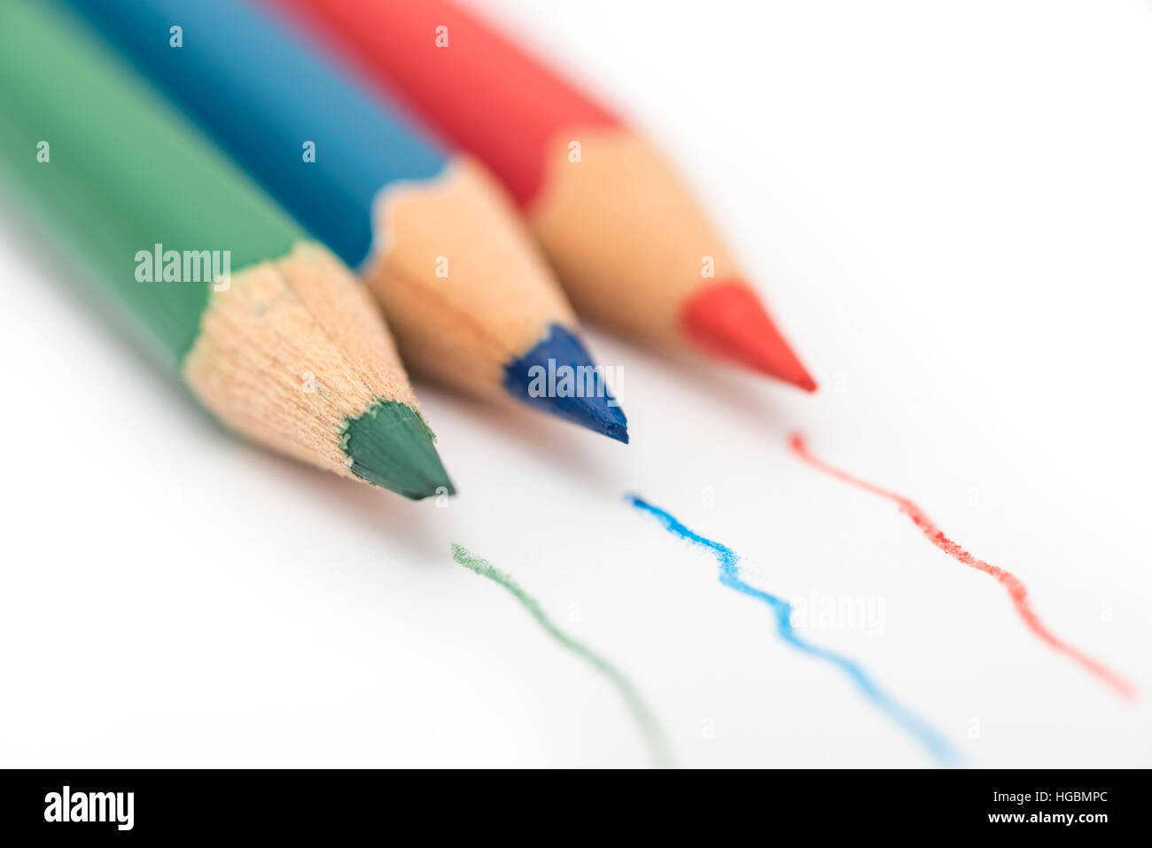 Matite colorate. Il rosso, il verde e il blu matite colorate isolato su un foglio bianco di carta con le linee tracciate dalla matita Foto Stock