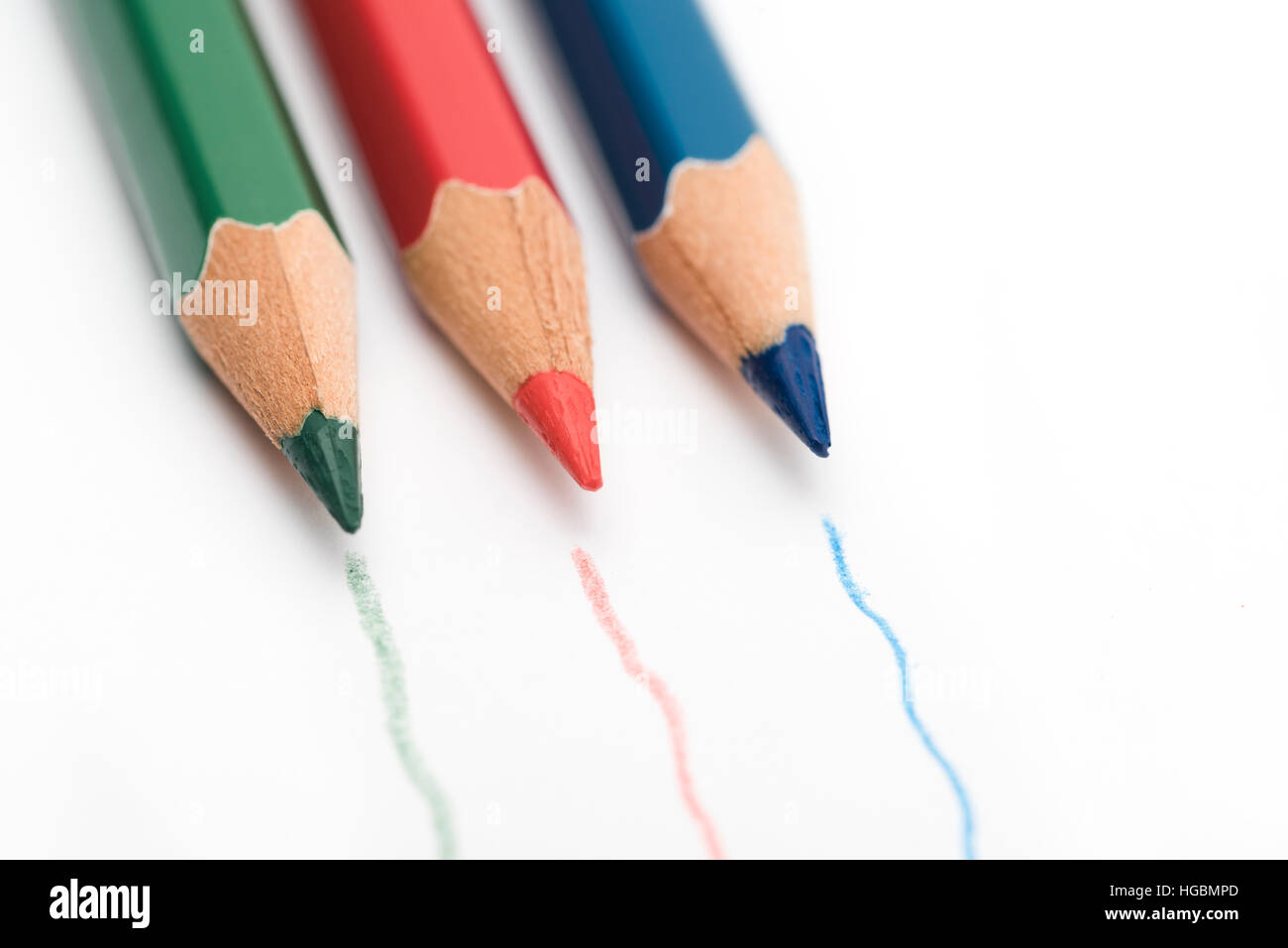 Matite colorate. Il rosso, il verde e il blu matite colorate isolato su un foglio bianco di carta con le linee tracciate dalla matita Foto Stock