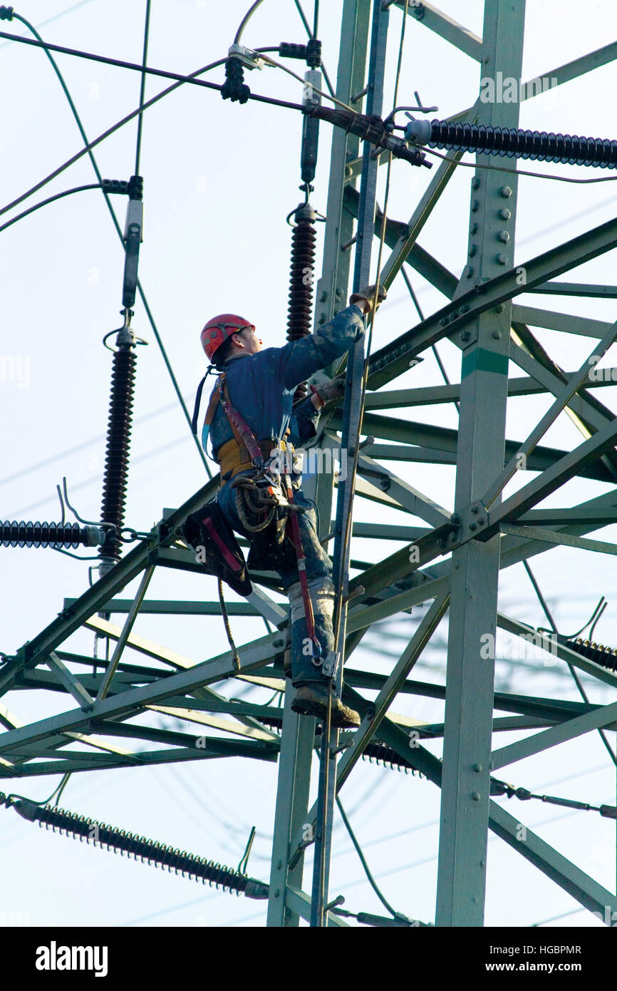 Lavoratore a una tensione elevata torre di trasmissione Foto Stock