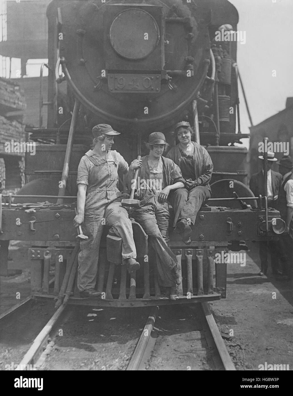 Le donne di operai seduti sulla parte anteriore del motore alla boccola terminale cantiere ferroviario, 1918. Foto Stock