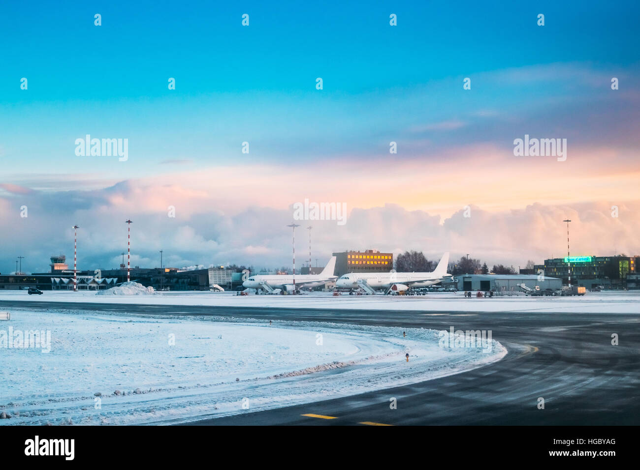 Riga, Lettonia - 1 Dicembre 2016: aerei stand presso il Riga International Airport Terminal in mattina presto con bella alba cielo drammatico. Foto Stock