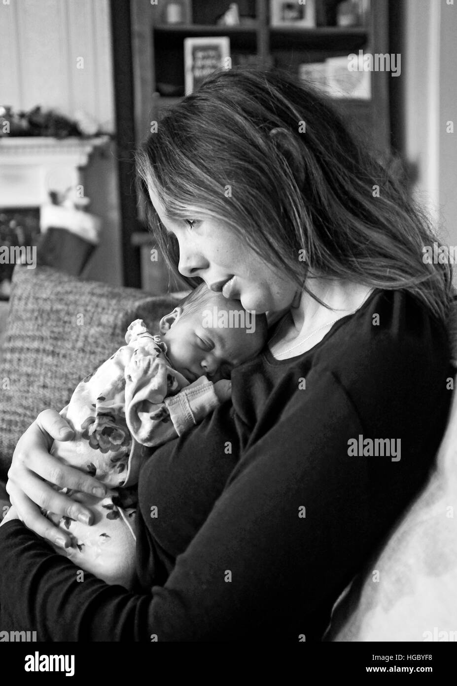 Giovane madre cuddling il suo neonato Foto Stock