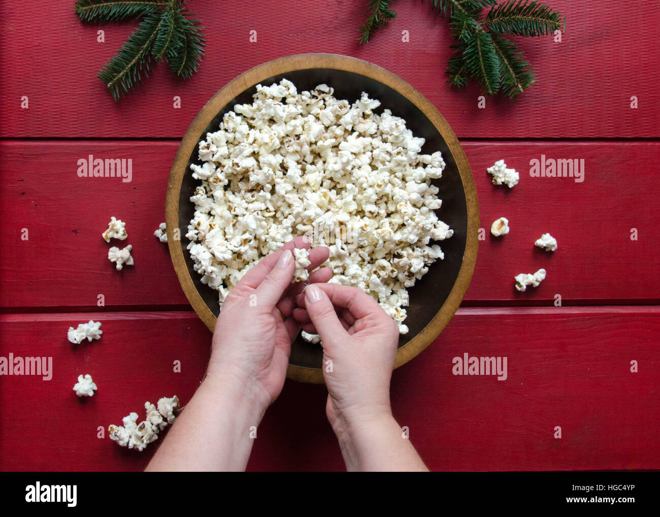 Mano Womans stringing popcorn per rendere garland per l'albero di Natale. Foto Stock