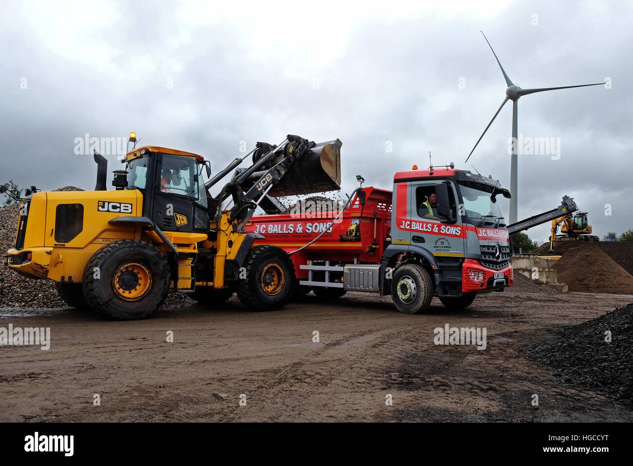 JCB 435s il riempimento J C sfere e figli Mercedes-Benz Arocs tre-assale carrello del cassone ribaltabile Foto Stock