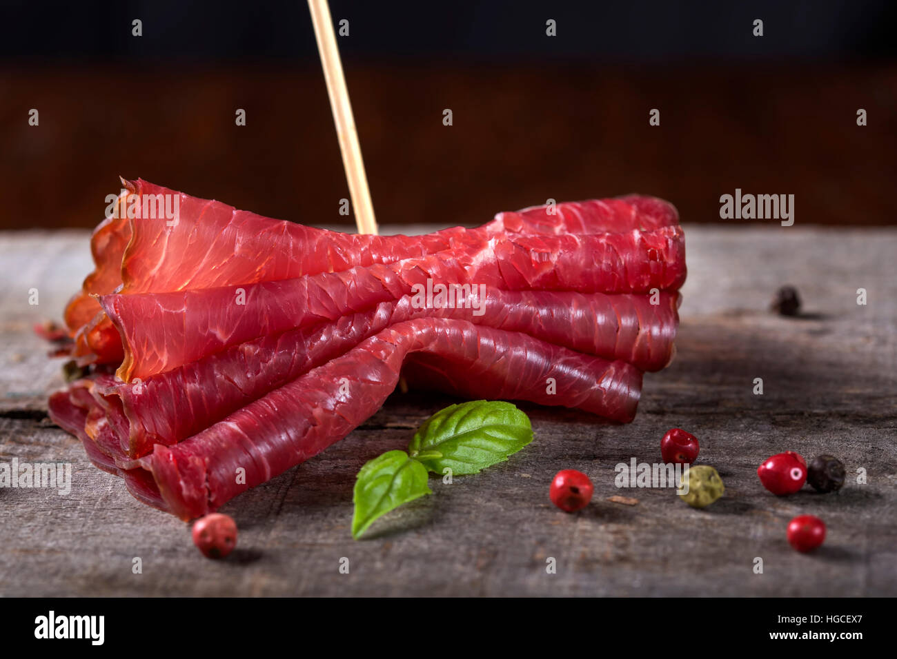 Carne di manzo affumicato fette di carne su sfondo di legno Foto Stock